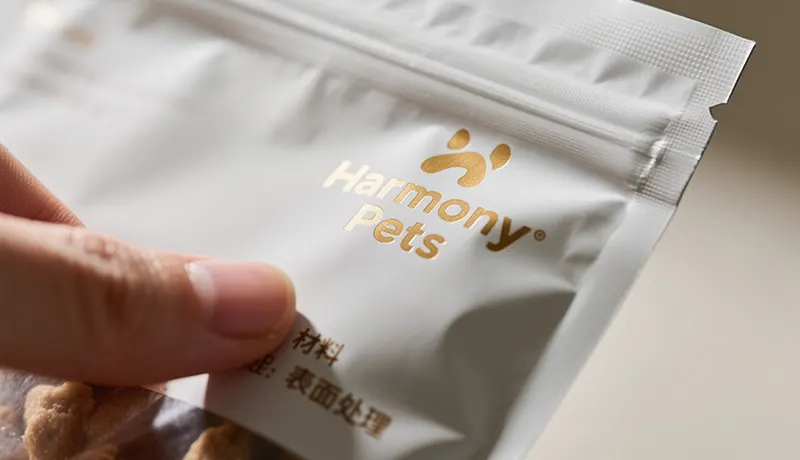 宠物包装设计材料与工艺细节特写，展示磨砂质感与烫金Logo，诠释CMF设计如何提升宠物品牌形象与用户体验，来自奥扬宠物品牌设计公司的专业视角
